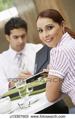 Stock Image - Business woman with colleague, portrait. Fotosearch