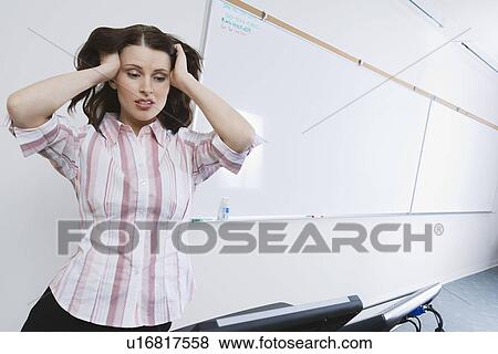 Business woman with head in hands, standing by whiteboard View Large Photo Image Stock Photo - Business woman with head in hands, standing by whiteboard. Fotosearch