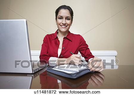 Business woman writing in diary beside laptop in office, portrait View Large Photo Image Stock Image - Business woman writing in diary beside laptop in office, portrait. Fotosearch