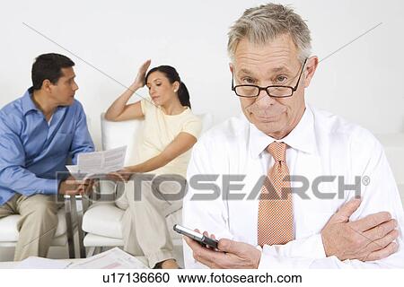 Stock Image - Businessman Assisting Couple. Fotosearch