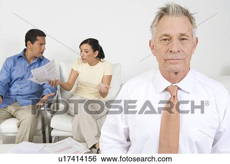 Stock Photograph - Businessman Assisting Couple. Fotosearch