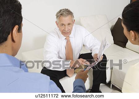 Businessman Assisting Couple with Credit Cards View Large Photo Image Stock Image - Businessman Assisting Couple with Credit Cards. Fotosearch