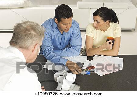 Businessman Assisting Couple with Credit Cards View Large Photo Image Stock Photograph - Businessman Assisting Couple with Credit Cards. Fotosearch