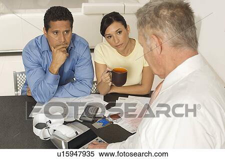 Stock Photography - Businessman Assisting Couple with Credit Cards. Fotosearch