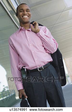 Businessman holding coat over shoulder, portrait View Large Photo Image Stock Image - Businessman holding coat over shoulder, portrait. Fotosearch