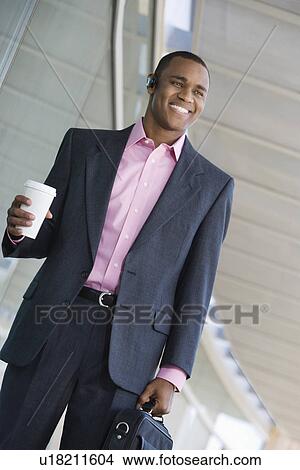 Picture - Businessman holding takeout coffee and briefcase. Fotosearch