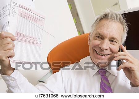 Stock Photograph - Businessman Holding Tax Forms. Fotosearch