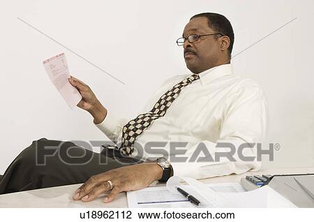 Stock Image - Businessman Looking at a Bill. Fotosearch