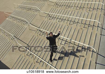 Stock Photo - Businessman shouting on stairs, elevated view. Fotosearch