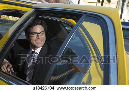 Picture - Businessman sitting in taxi. Fotosearch