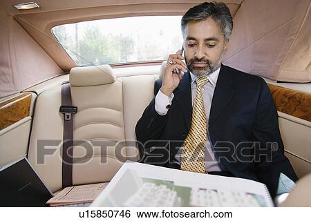 Businessman Using Cell Phone in Private Car View Large Photo Image Stock Photograph - Businessman Using Cell Phone in Private Car. Fotosearch