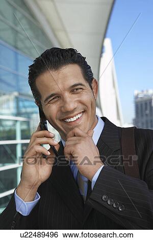 Stock Photograph - Businessman using mobile phone outside office building. Fotosearch