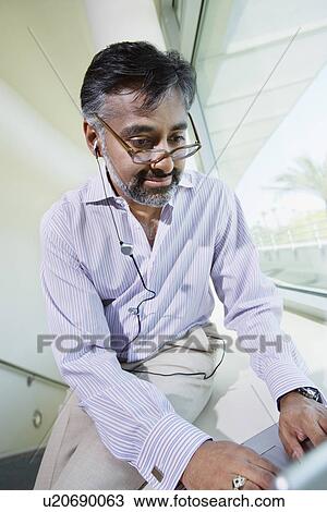 Businessman Using Telephone Earbud and Laptop View Large Photo Image Stock Image - Businessman Using Telephone Earbud and Laptop. Fotosearch