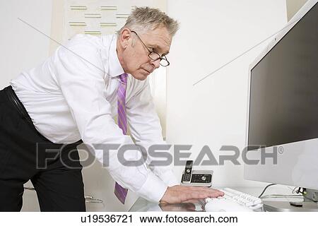 Stock Image - Businessman Working at Desk. Fotosearch