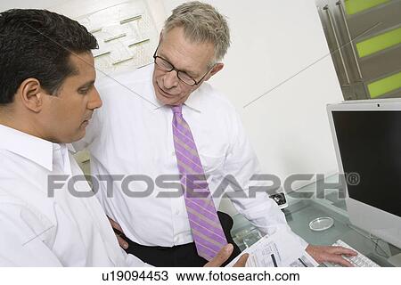 Stock Image - Businessmen Working in Office. Fotosearch