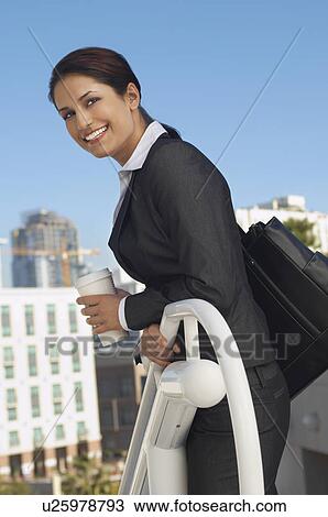 Businesswoman leaning on railing outdoors, portrait View Large Photo Image Stock Image - Businesswoman leaning on railing outdoors, portrait. Fotosearch