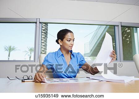 Stock Photo - Businesswoman Looking at Paperwork. Fotosearch