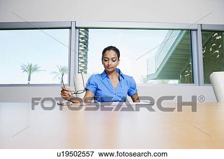 Stock Photo - Businesswoman Reading Booklet. Fotosearch