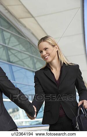 Businesswoman shaking hands with businessman outdoors View Large Photo Image Picture - Businesswoman shaking hands with businessman outdoors. Fotosearch