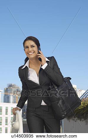 Businesswoman talking on mobile phone outdoors View Large Photo Image Stock Photography - Businesswoman talking on mobile phone outdoors. Fotosearch