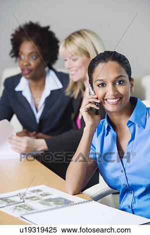 Businesswoman Using Cell Phone During meeting View Large Photo Image Stock Photography - Businesswoman Using Cell Phone During meeting. Fotosearch