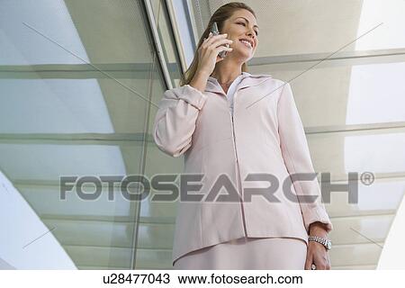 Businesswoman using cell phone on balcony View Large Photo Image Stock Image - Businesswoman using cell phone on balcony. Fotosearch