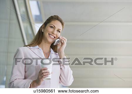 Businesswoman using cell phone with takeout coffee outdoors View Large Photo Image Stock Image - Businesswoman using cell phone with takeout coffee outdoors. Fotosearch