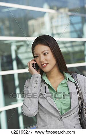 Stock Photo - Businesswoman using mobile phone outdoors. Fotosearch