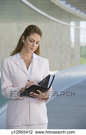 Businesswoman writing in planner outdoors View Large Photo Image Stock Image - Businesswoman writing in planner outdoors. Fotosearch