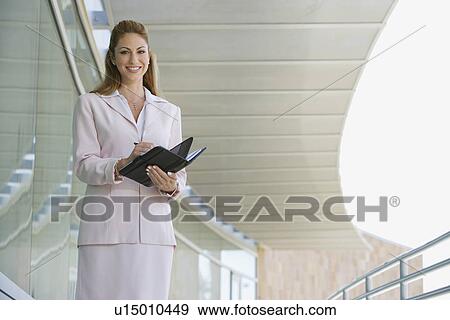 Stock Photo - Businesswoman writing in planner outdoors, portrait. Fotosearch