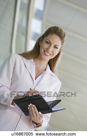 Businesswoman writing in planner outdoors, portrait View Large Photo Image Stock Photography - Businesswoman writing in planner outdoors, portrait. Fotosearch