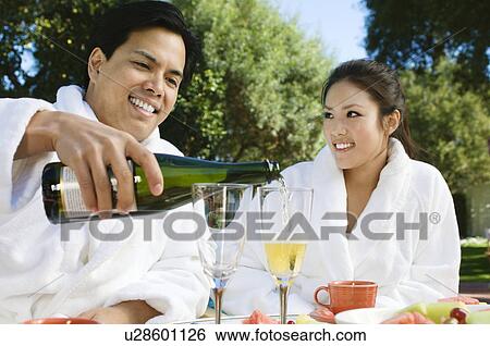 Chinese couple wearing bathrobes, drinking champagne at outdoor table View Large Photo Image Stock Photograph - Chinese couple wearing bathrobes, drinking champagne at outdoor table. Fotosearch