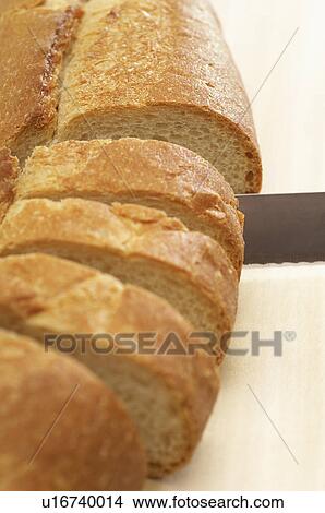 Close-up of knife slicing baguette View Large Photo Image Picture - Close-up of knife slicing baguette. Fotosearch