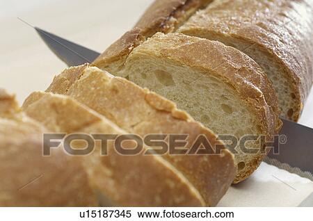 Close-up of knife slicing baguette View Large Photo Image Stock Photography - Close-up of knife slicing baguette. Fotosearch