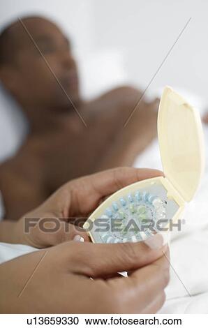 Close-up of woman's hands holding pills, man in background View Large Photo Image Stock Image - Close-up of woman's hands holding pills, man in background. Fotosearch