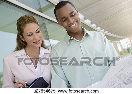 Colleagues looking at blueprints View Large Photo Image Stock Photography - Colleagues looking at blueprints. Fotosearch