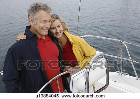 Couple at helm of sailboat, smiling, elevated view View Large Photo Image Stock Photography - Couple at helm of sailboat, smiling, elevated view. Fotosearch