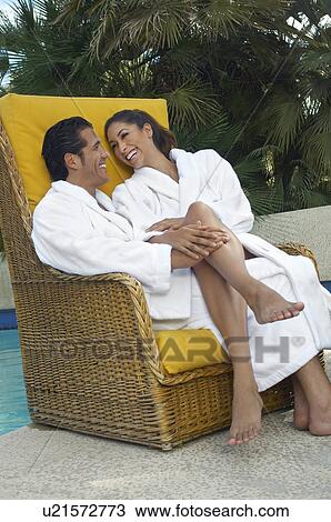 Couple in bathrobes relaxing in chair by pool View Large Photo Image Stock Image - Couple in bathrobes relaxing in chair by pool. Fotosearch