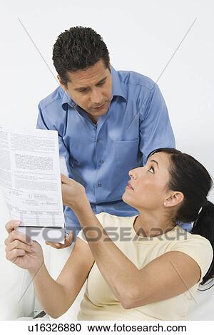 Stock Image - Couple Looking at Tax Form. Fotosearch