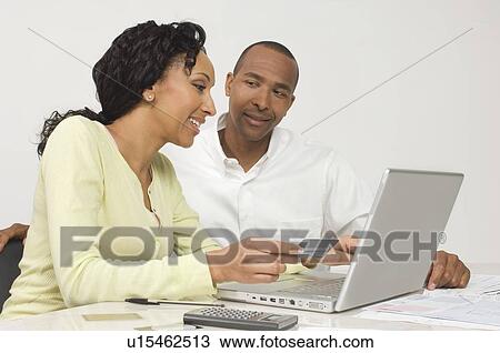 Stock Image - Couple Making an Online Transaction. Fotosearch