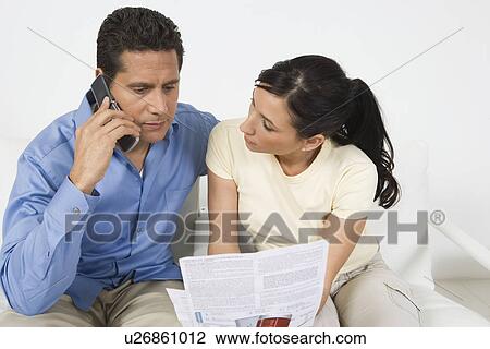 Stock Image - Couple Paying Bill on Phone. Fotosearch