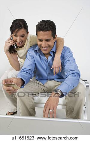 Stock Image - Couple Placing Order on Cell Phone. Fotosearch