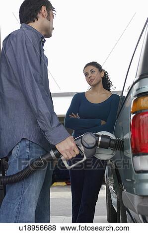 Stock Photo - Couple pumping gas. Fotosearch