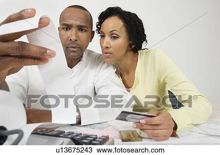 Stock Image - Couple Reading Adding Machine Tape. Fotosearch