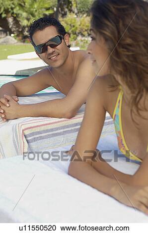 Stock Image - Couple relaxing on deck chairs. Fotosearch