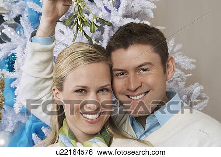 Couple under mistletoe, portrait View Large Photo Image Stock Photograph - Couple under mistletoe, portrait. Fotosearch
