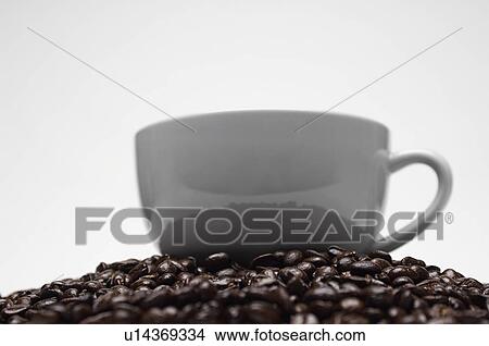 Picture - Cup of coffee on heap of coffee beans. Fotosearch