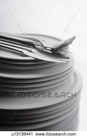 Stock Image - Cutlery on stack of plates. Fotosearch