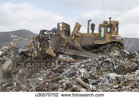 Digger moving waste at landfill site View Large Photo Image Stock Image - Digger moving waste at landfill site. Fotosearch