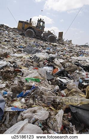 Digger working at landfill site View Large Photo Image Stock Image - Digger working at landfill site. Fotosearch